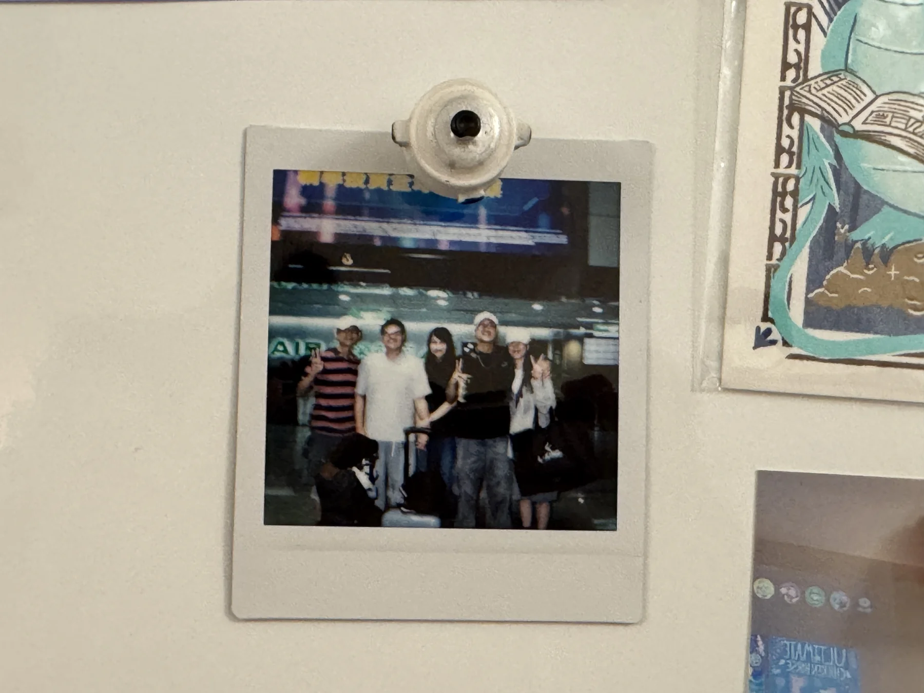 The airport Polaroid of my family, my girlfriend, and me, displayed on my apartment wall