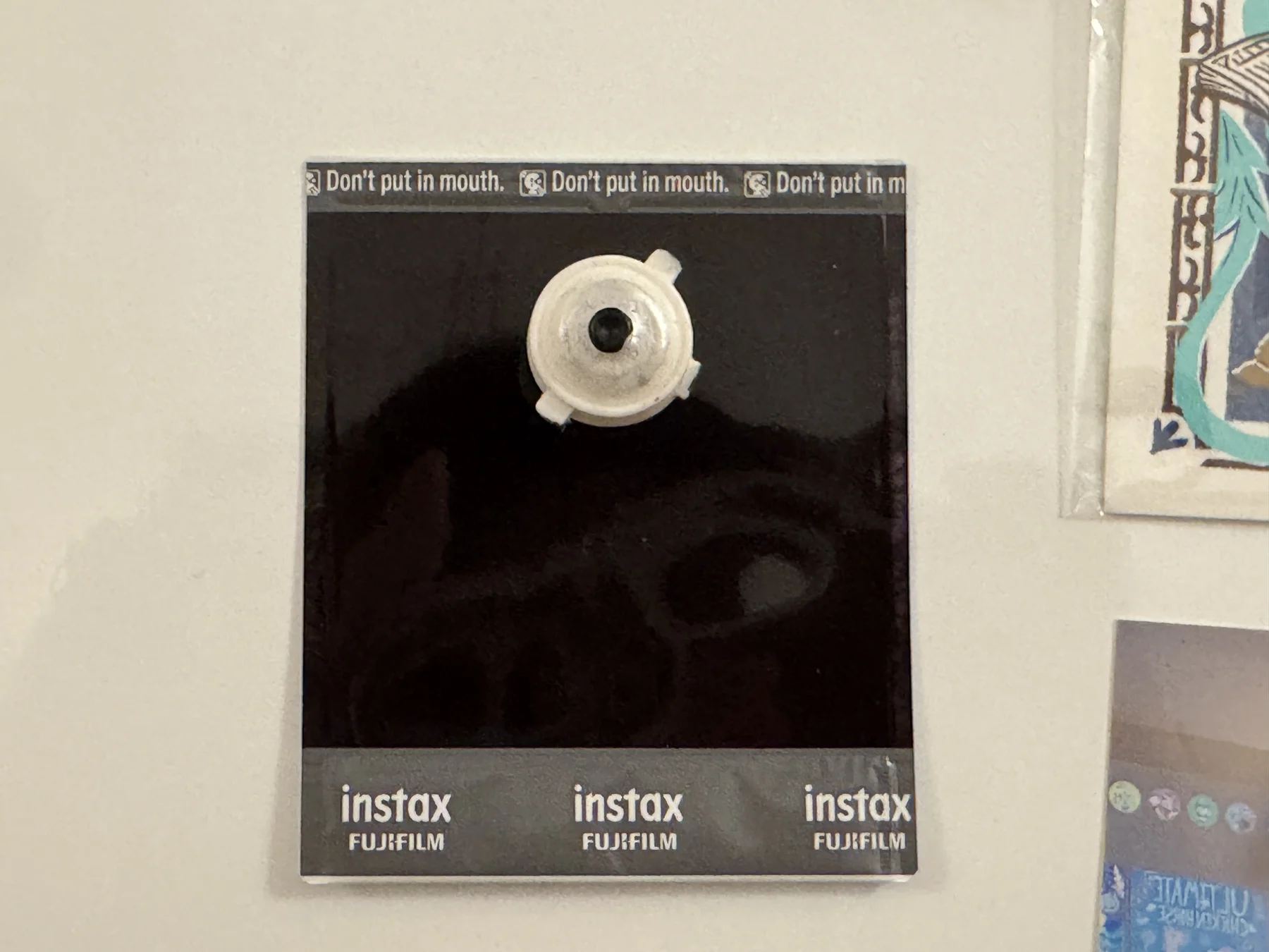 The back of the airport Polaroid, held on the wall with a magnet