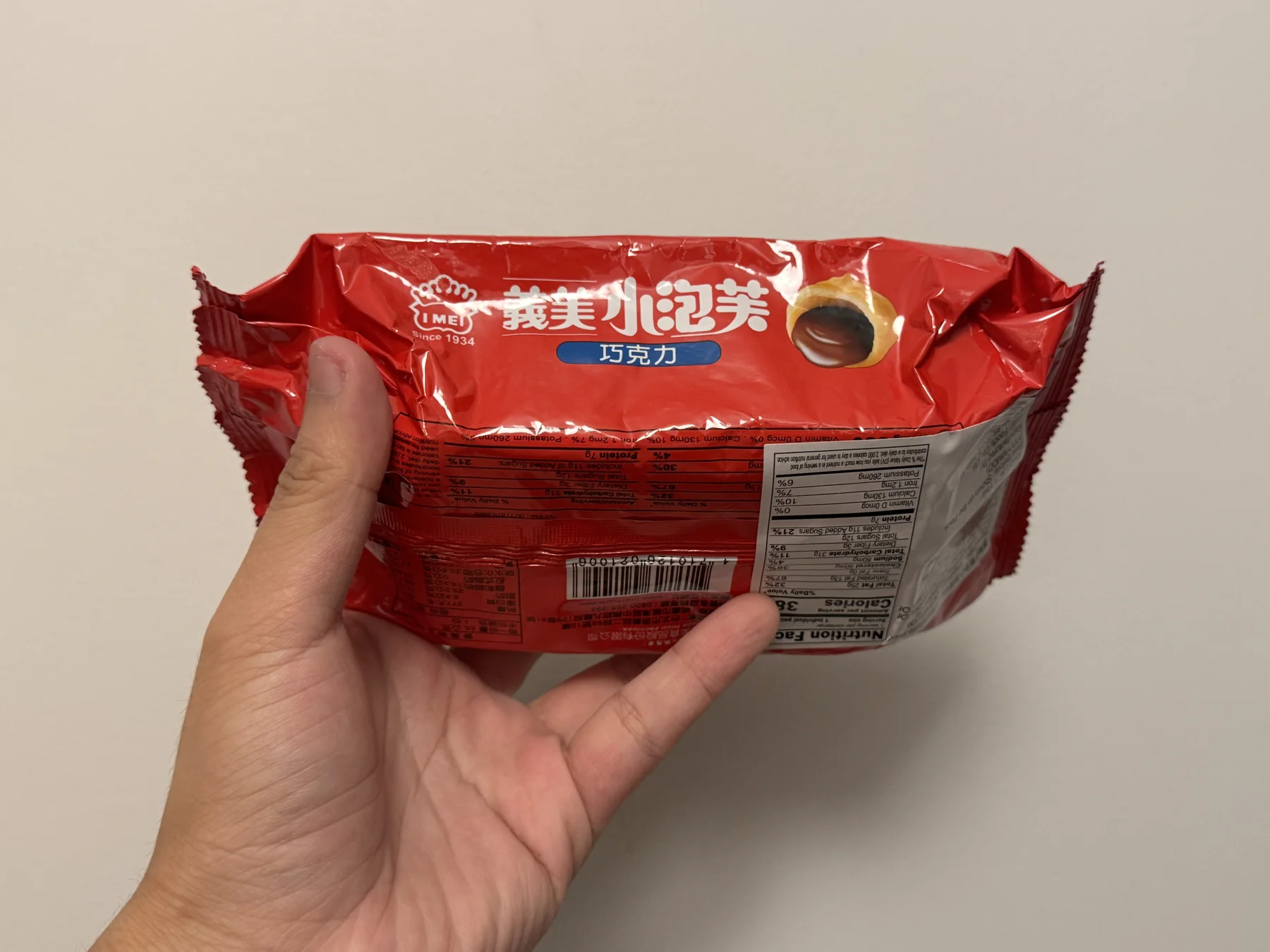 A hand holding the reverse of the I-Mei chocolate mini puffs package