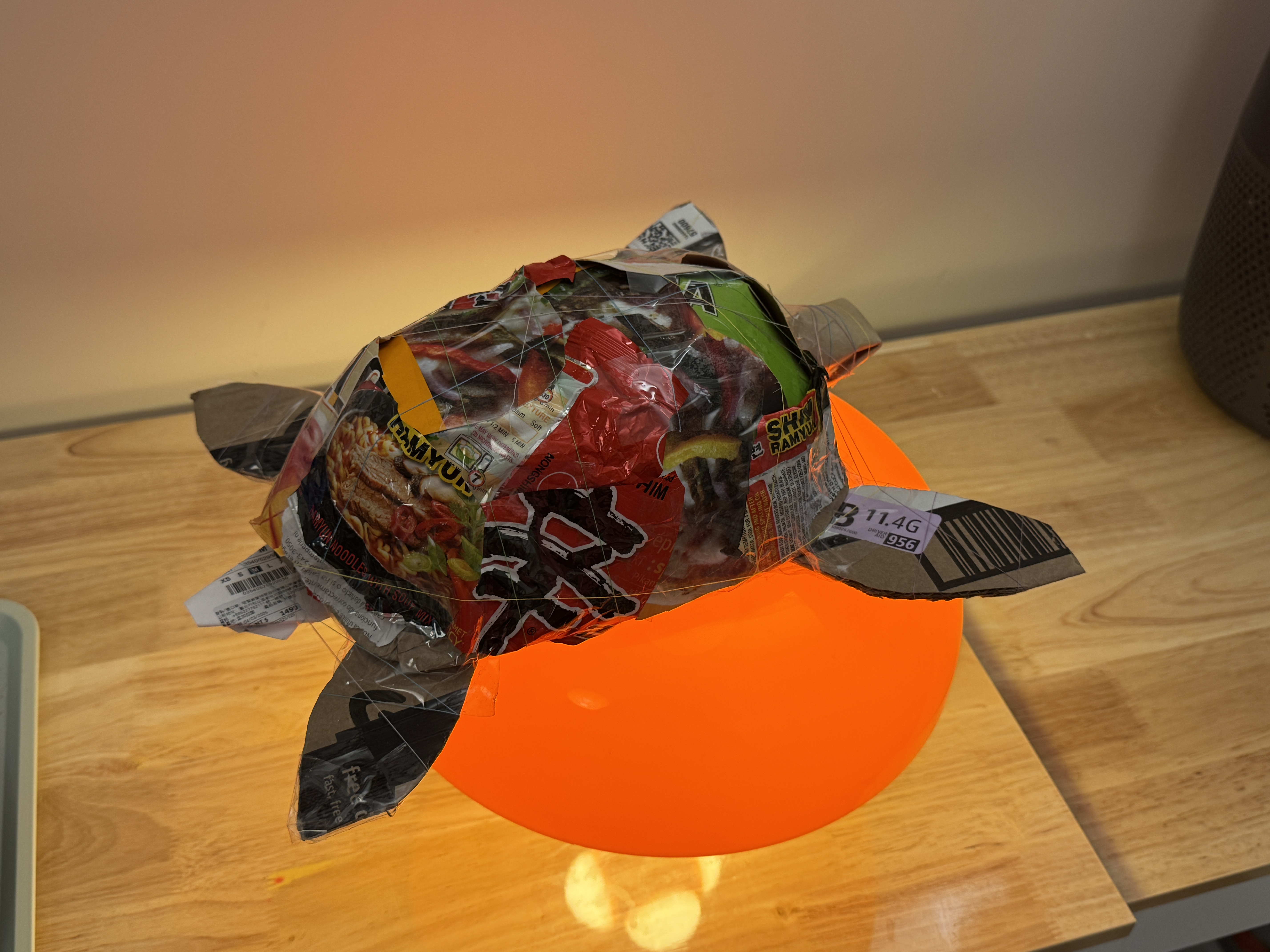 Completed recycled-material Hawksbill Sea Turtle sculpture resting on an orange glowing light.